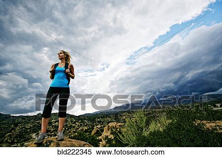 Stock Photography - Caucasian woman standing on rural hilltop. Fotosearch