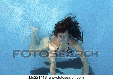 Stock Image - Caucasian woman swimming in pool. Fotosearch