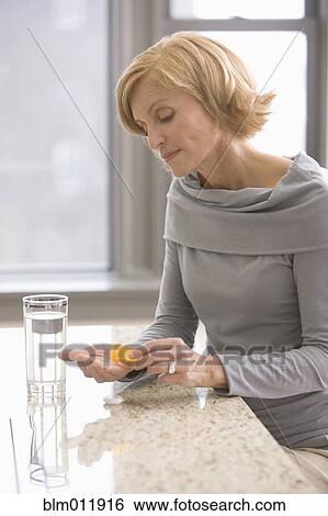 Stock Photograph - Caucasian woman taking medicine. Fotosearch