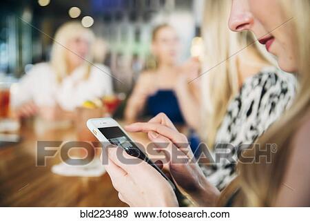 Caucasian woman using cell phone at bar View Large Photo Image Stock Photo - Caucasian woman using cell phone at bar. Fotosearch