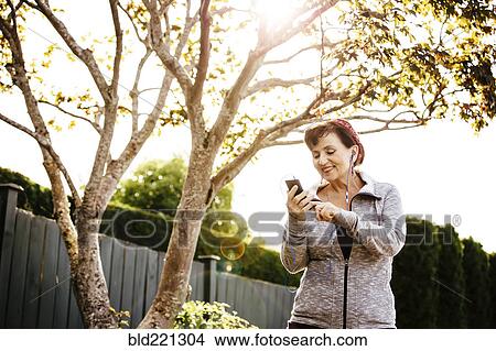 Caucasian woman using cell phone outdoors View Large Photo Image Picture - Caucasian woman using cell phone outdoors. Fotosearch