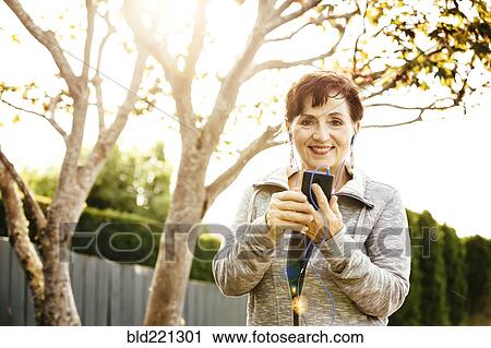 Stock Image - Caucasian woman using cell phone outdoors. Fotosearch