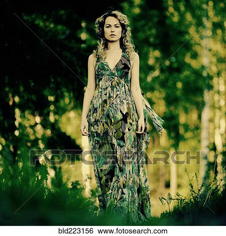 Stock Photograph - Caucasian woman walking in grass. Fotosearch