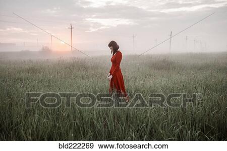 Stock Photo - Caucasian woman walking in remote field. Fotosearch