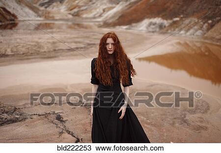 Stock Image - Caucasian woman walking in remote landscape. Fotosearch