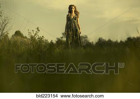 Picture - Caucasian woman walking in rural field. Fotosearch