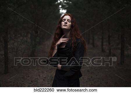 Stock Image - Caucasian woman walking on forest path. Fotosearch