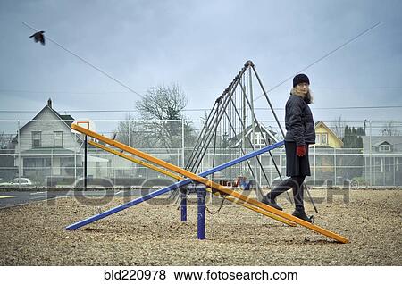 Caucasian woman walking on playground seesaw View Large Photo Image Stock Photo - Caucasian woman walking on playground seesaw. Fotosearch
