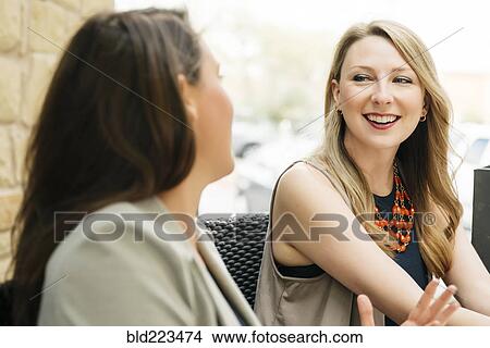 Picture - Caucasian women talking at table. Fotosearch