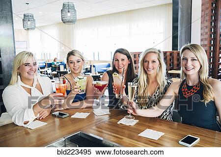 Caucasian women toasting at bar with cocktails View Large Photo Image Stock Photography - Caucasian women toasting at bar with cocktails. Fotosearch