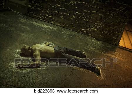 Stock Image - Chalk outline around body of Caucasian victim on pavement. Fotosearch