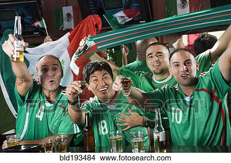 Picture - Cheering men drinking in sports bar. Fotosearch