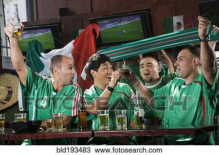 Stock Image - Cheering men watching television in sports bar. Fotosearch