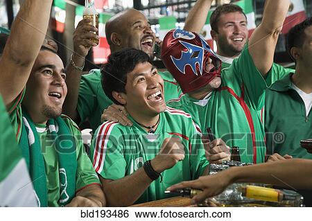 Cheering men watching television in sports bar View Large Photo Image Stock Photograph - Cheering men watching television in sports bar. Fotosearch