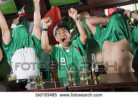Cheering men watching television in sports bar View Large Photo Image Stock Photography - Cheering men watching television in sports bar. Fotosearch