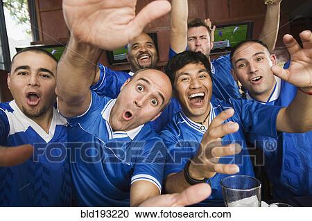 Stock Image - Cheering teammates in sports bar. Fotosearch