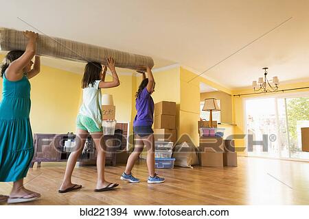 Picture - Children carrying carpet in new house. Fotosearch