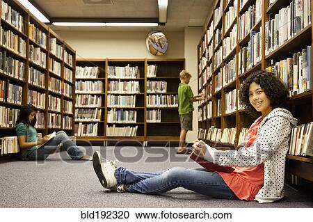Stock Image - Children reading books in library. Fotosearch