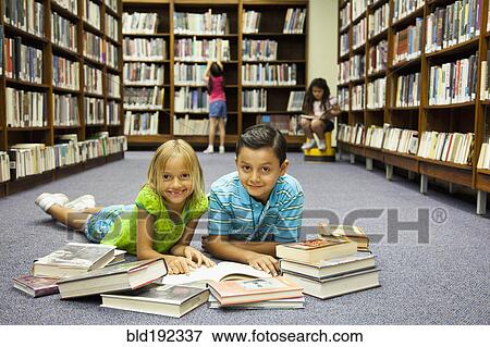 Stock Photo - Children reading books on library floor. Fotosearch