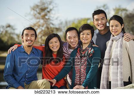Stock Image - Chinese family smiling outdoors. Fotosearch