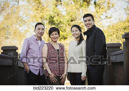 Stock Image - Chinese family smiling outdoors. Fotosearch