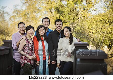 Stock Image - Chinese family smiling outdoors. Fotosearch