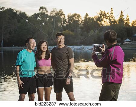 Chinese family taking photograph in park View Large Photo Image Stock Photo - Chinese family taking photograph in park. Fotosearch
