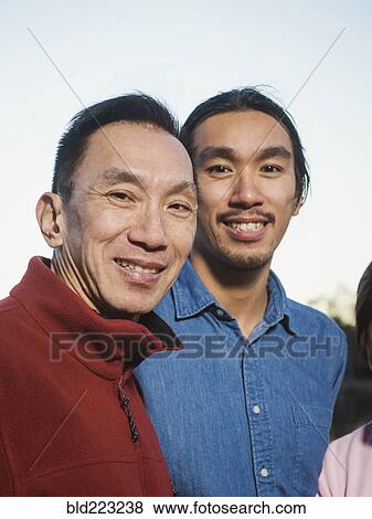 Stock Photo - Chinese father and son smiling outdoors. Fotosearch