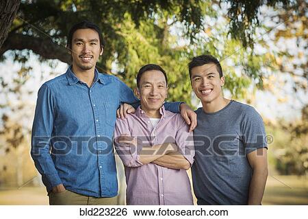 Chinese father and sons smiling outdoors View Large Photo Image Stock Photograph - Chinese father and sons smiling outdoors. Fotosearch