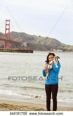 Chinese girl holding dog on beach View Large Photo Image Stock Image - Chinese girl holding dog on beach. Fotosearch