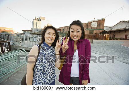 Stock Photo - Chinese mother and daughter making peace sign. Fotosearch