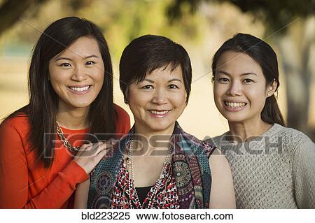 Stock Photography - Chinese mother and daughters posing outdoors. Fotosearch