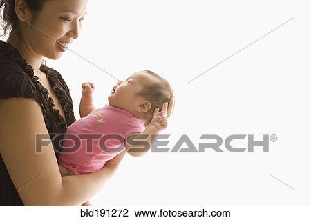 Chinese mother holding baby daughter View Large Photo Image Stock Image - Chinese mother holding baby daughter. Fotosearch