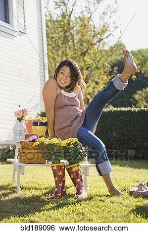 Stock Photograph - Chinese woman kicking up feet in garden. Fotosearch