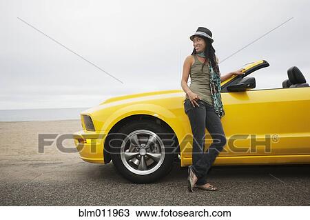 Chinese woman standing near convertible at beach View Large Photo Image Stock Image - Chinese woman standing near convertible at beach. Fotosearch