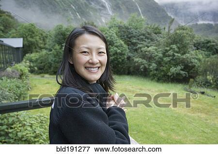Chinese woman standing on balcony in remote area View Large Photo Image Stock Photo - Chinese woman standing on balcony in remote area. Fotosearch
