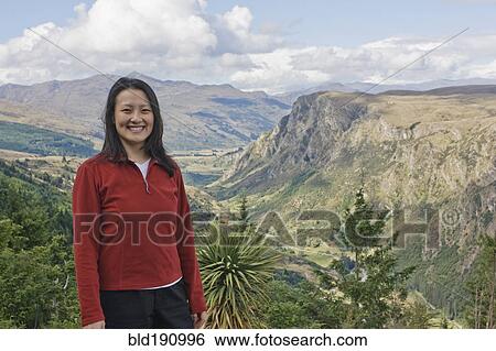 Chinese woman standing on hilltop with remote valley in distance View Large Photo Image Stock Photograph - Chinese woman standing on hilltop with remote valley in distance. Fotosearch