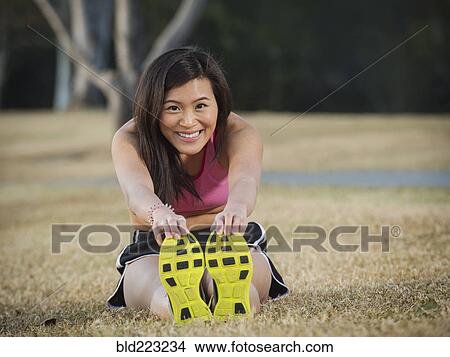 Picture - Chinese woman stretching in park. Fotosearch