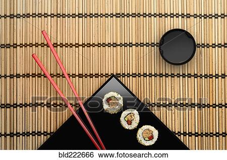 Stock Photograph - Chopsticks and sushi on square plate with dipping sauce. Fotosearch