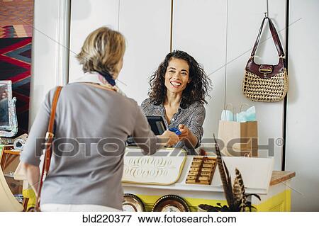 Stock Photo - Clerk helping customer in shop. Fotosearch