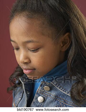Stock Photo - Close up of mixed race girl looking down. Fotosearch