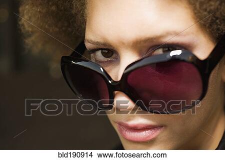 Picture - Close up of mixed race woman wearing sunglasses. Fotosearch