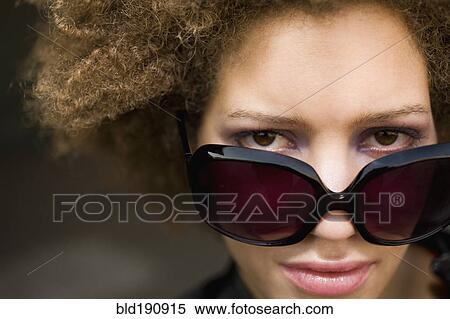 Stock Photography - Close up of mixed race woman wearing sunglasses. Fotosearch