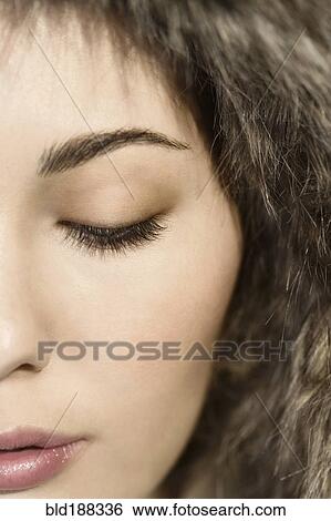 Stock Photograph - Close up of Mixed Race woman with eyes closed. Fotosearch