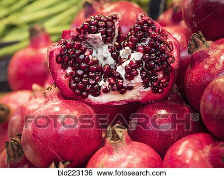 Stock Photograph - Close up of seeds in sliced pomegranate pile. Fotosearch
