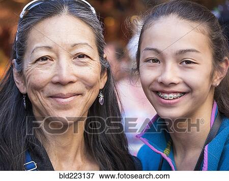 Close up of smiling Asian mother and daughter View Large Photo Image Stock Photo - Close up of smiling Asian mother and daughter. Fotosearch