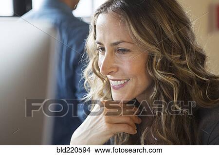 Picture - Close up of smiling businesswoman working at computer. Fotosearch