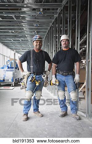 Stock Image - Co-workers on construction site. Fotosearch