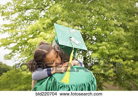 Picture - College graduate father hugging daughter. Fotosearch