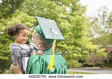 Stock Photography - College graduate father hugging daughter. Fotosearch